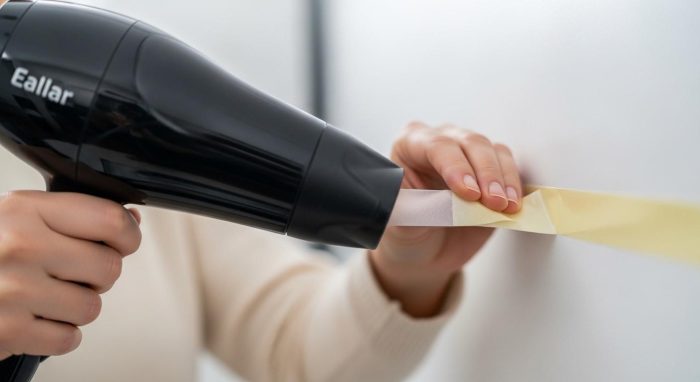 ドライヤーで温めながらテープを剥がす様子